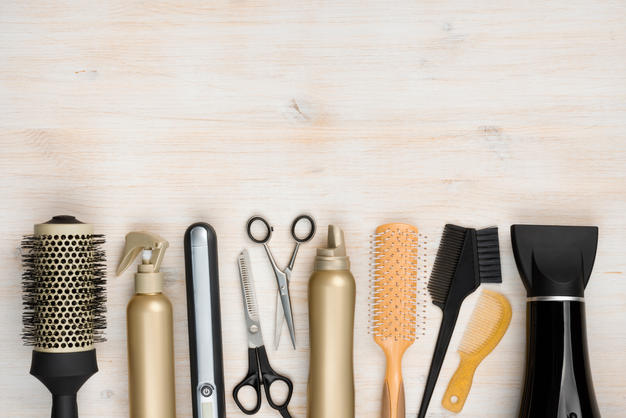 Hairdressing tools on wooden background with copy space at top